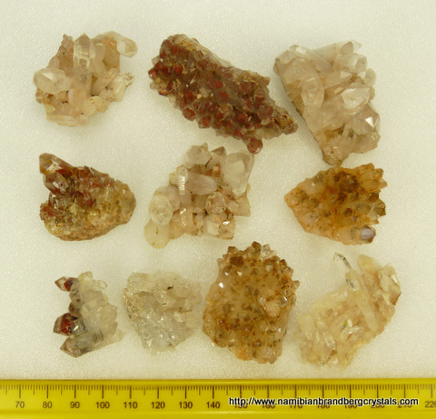 Ten quartz crystal specimens from greyish-white to amethyst colour