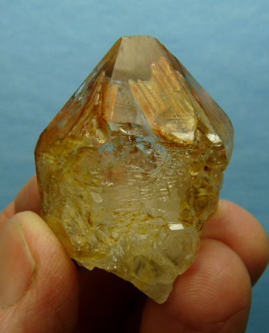 Window quartz crystal with orangy-red inclusions