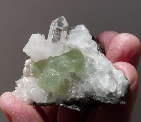 Green bladed balls of prehnite alongside lovely quartz crystal, on matrix