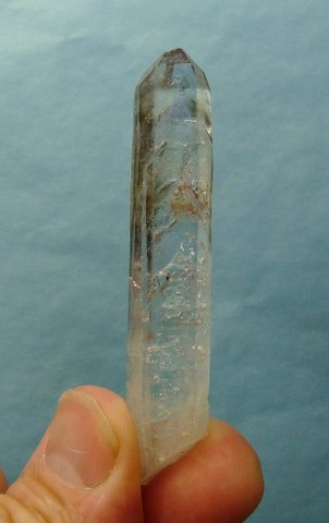 Long, slender quartz crystal with tiny bubbles