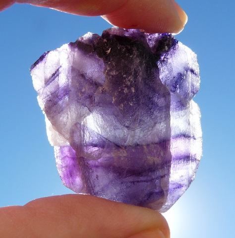 Banded fluorite crystal with different shades of purple colouring