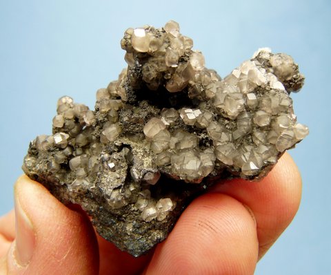 Greyish smithsonite crystals in and on metallic ore