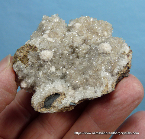 Sparkling, gemmy calcite crystal with aggregates of oyelite, on matrix