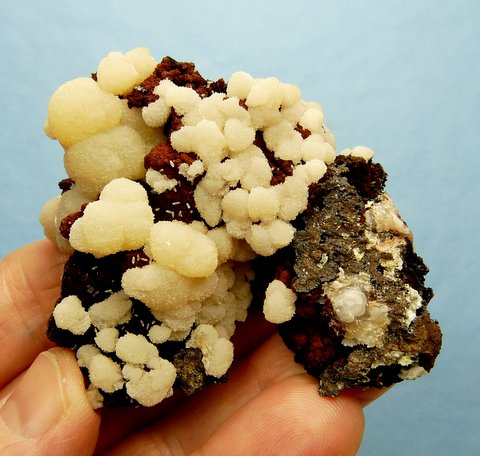 Manganoam calcite aggregates on goethite, on manganese, on rock matrix