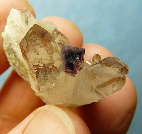 Purple colour-zoned fluorite crystal on phantom quartz crystals, on matrix