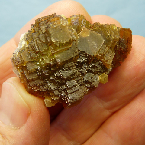 A yellowish-green stepped fluorite crystal specimen, on matrix