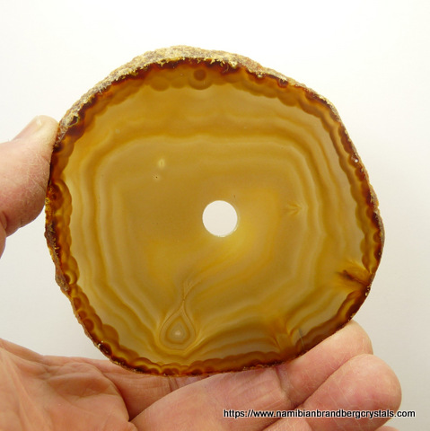 A slice of polished agate with a hole