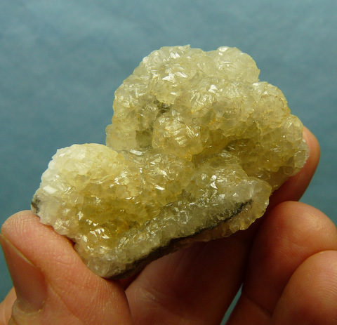 Pearly, semi-clear smithsonite crystals sit on matrix